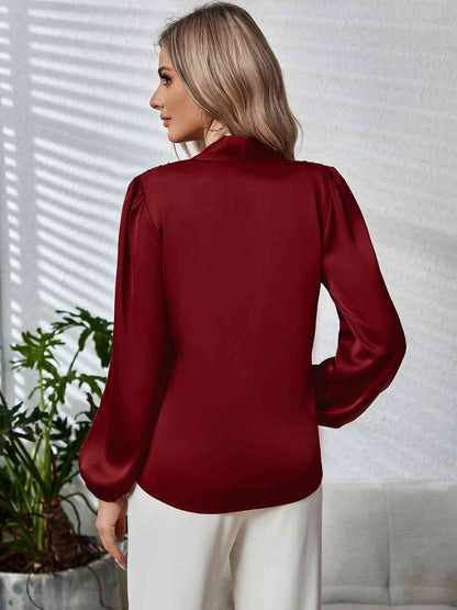 Blouse à manches longues bouffantes et col noué